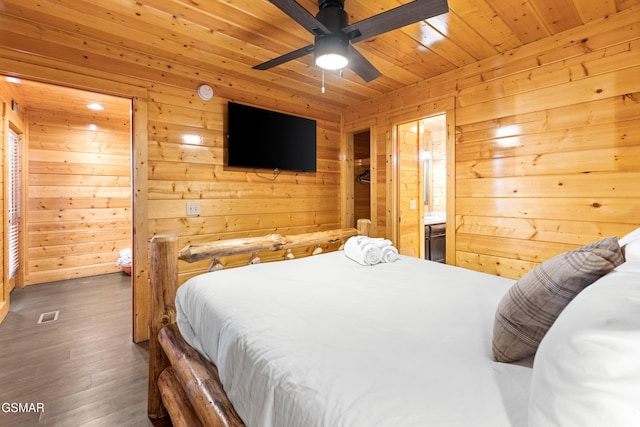 bedroom with wooden ceiling, ensuite bath, wooden walls, dark wood-type flooring, and ceiling fan