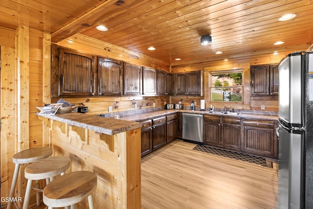 kitchen with kitchen peninsula, dark brown cabinets, light hardwood / wood-style flooring, appliances with stainless steel finishes, and wooden ceiling