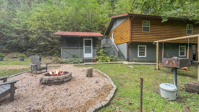 view of front of property with an outdoor fire pit and a sunroom