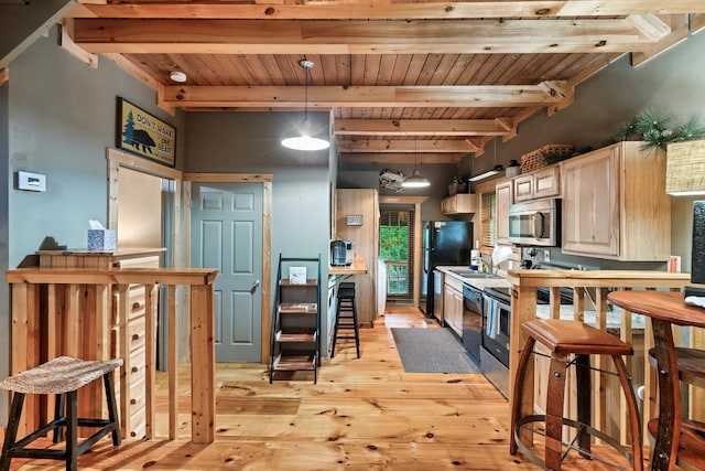 kitchen with black appliances, light brown cabinets, pendant lighting, light hardwood / wood-style flooring, and beamed ceiling