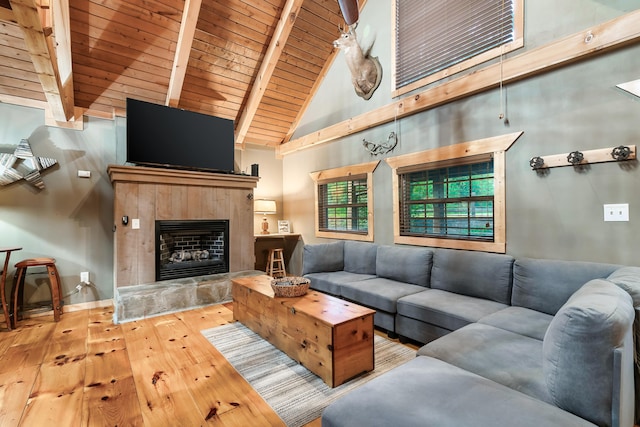 living room featuring wooden ceiling, high vaulted ceiling, hardwood / wood-style flooring, a fireplace, and beamed ceiling