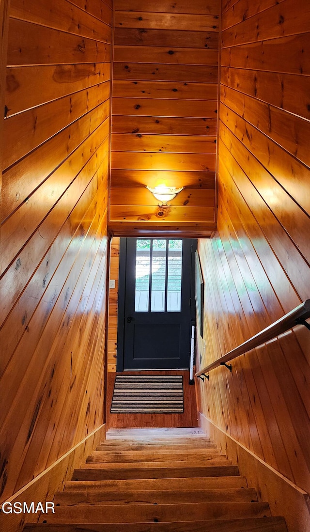 staircase featuring wooden walls