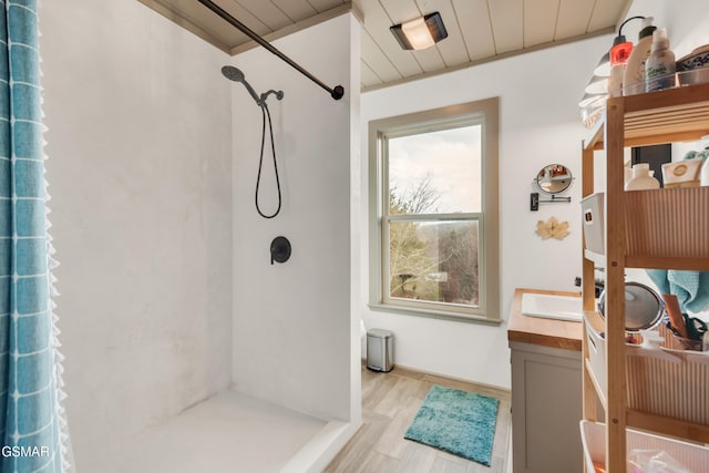 bathroom with hardwood / wood-style flooring, vanity, and walk in shower