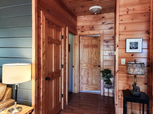 hall featuring wood ceiling, dark wood-type flooring, and wooden walls