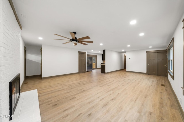 unfurnished living room featuring light wood-style flooring, recessed lighting, a fireplace, a ceiling fan, and baseboards