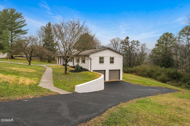 view of front facade featuring a garage, driveway, and a front yard