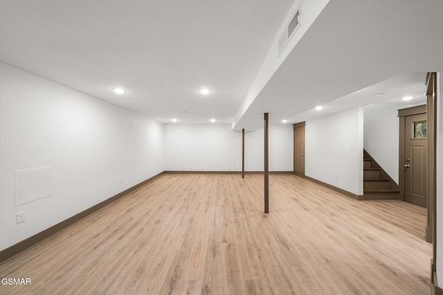 finished below grade area featuring recessed lighting, visible vents, light wood-style flooring, baseboards, and stairs