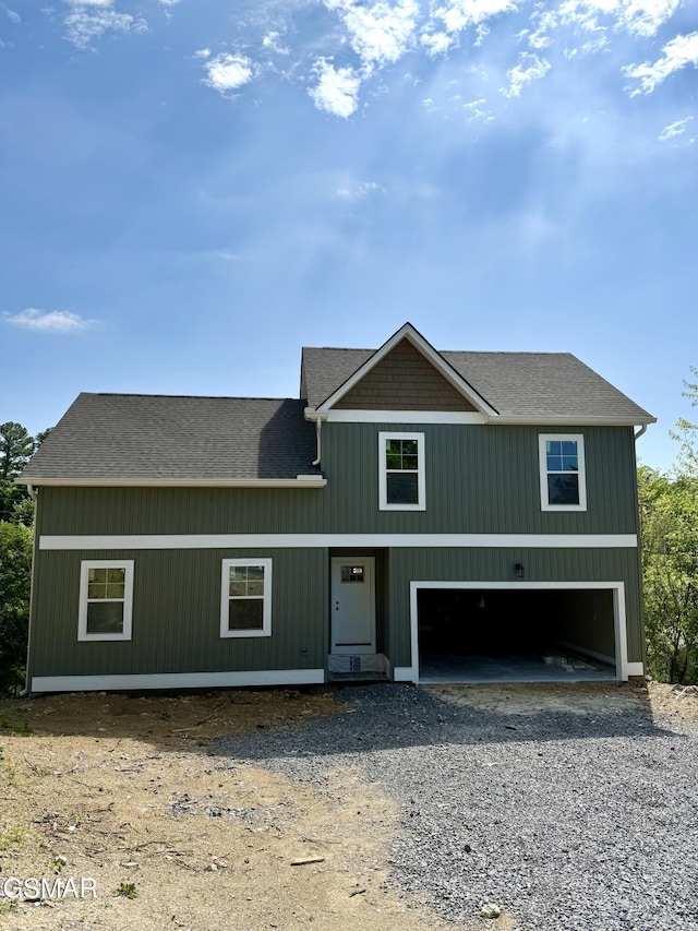 view of front of home with roof with shingles, driveway, and a garage