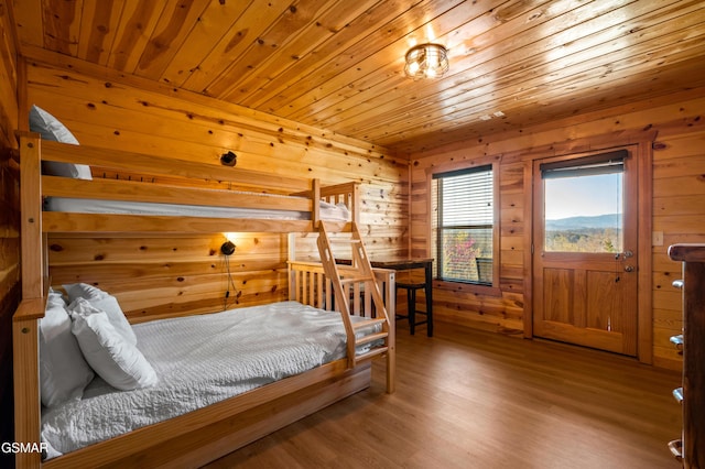 bedroom with hardwood / wood-style flooring, wood walls, and wooden ceiling