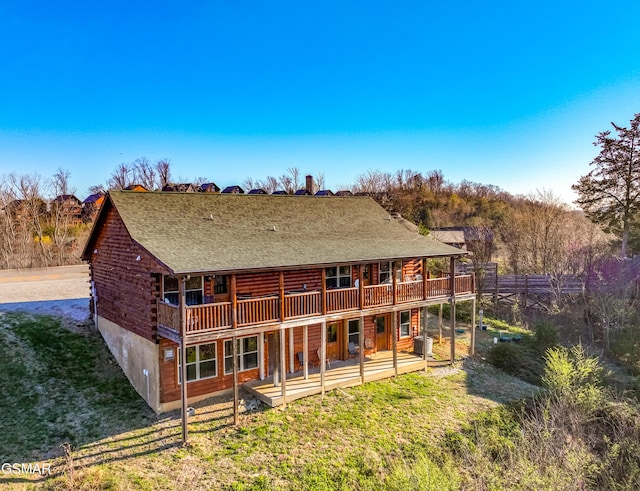 rear view of property featuring a lawn and a wooden deck