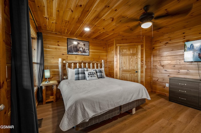 bedroom featuring ceiling fan, wood-type flooring, wood ceiling, and wood walls