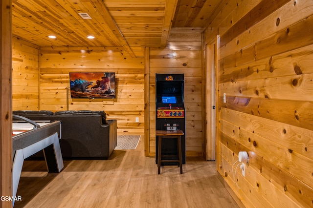 interior space featuring light wood-type flooring, wood walls, and wooden ceiling