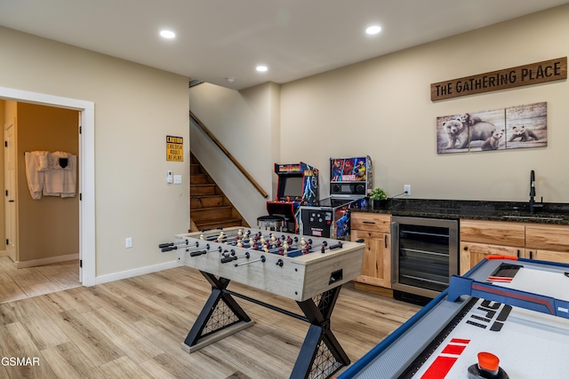 recreation room with light hardwood / wood-style flooring, wine cooler, and wet bar