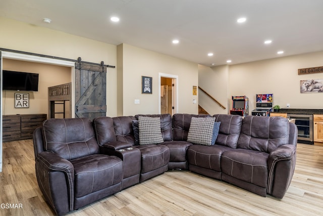 living room featuring a barn door, beverage cooler, and light hardwood / wood-style floors