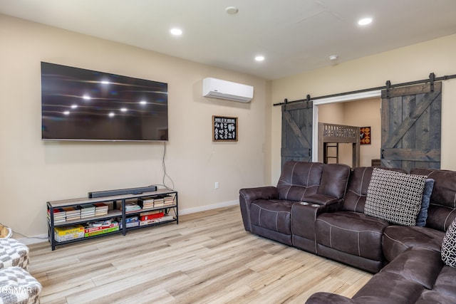 living room with light hardwood / wood-style floors, a barn door, and an AC wall unit