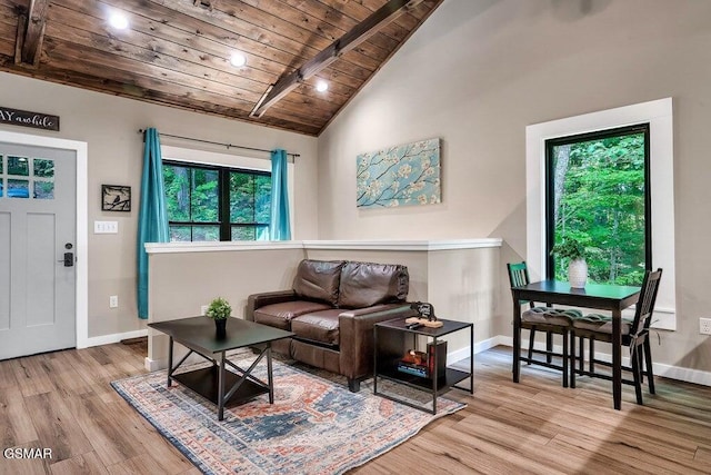 living room featuring lofted ceiling with beams, light wood-type flooring, and wooden ceiling