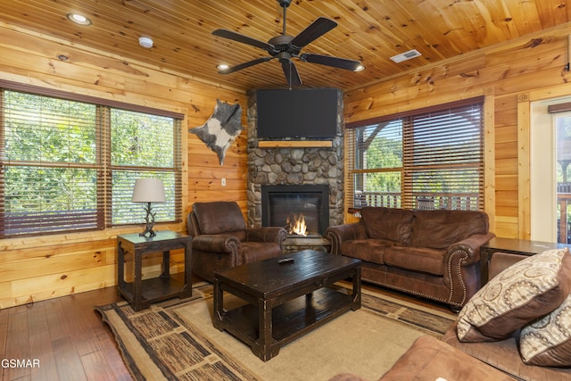 living room with a fireplace, hardwood / wood-style floors, ceiling fan, and wood ceiling