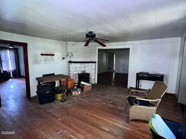 living room featuring a wood stove, ceiling fan, and hardwood / wood-style flooring