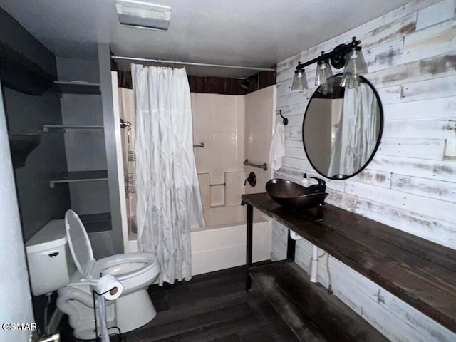 full bathroom featuring wood walls, toilet, shower / bath combo with shower curtain, and sink