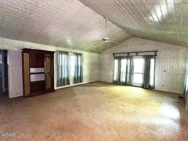 empty room featuring plenty of natural light, ceiling fan, and vaulted ceiling