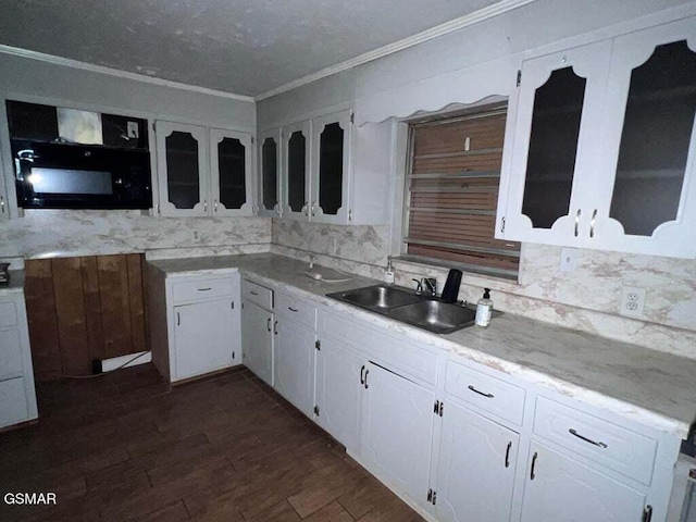 kitchen with backsplash, white cabinetry, ornamental molding, and sink