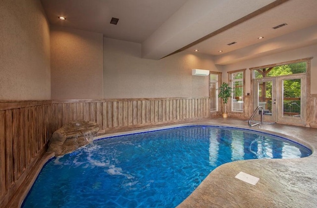 view of swimming pool with a wall mounted air conditioner, french doors, and pool water feature