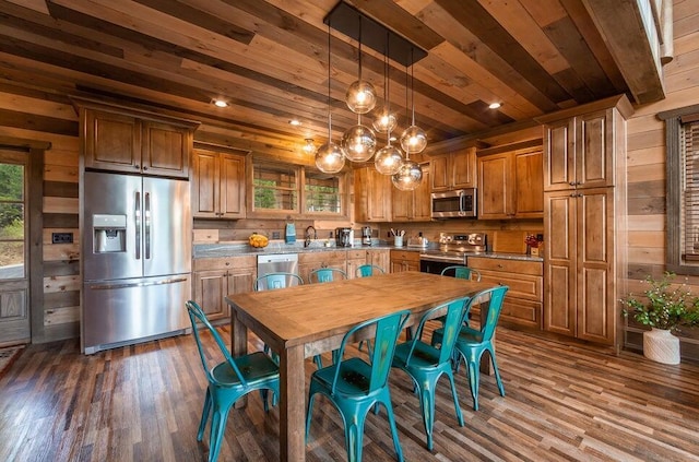 kitchen with appliances with stainless steel finishes, wooden walls, dark hardwood / wood-style flooring, and wooden ceiling