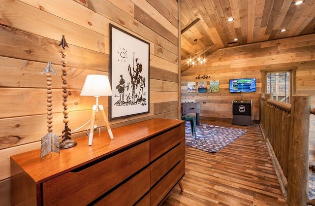 hall featuring hardwood / wood-style flooring, wood walls, wood ceiling, and a chandelier