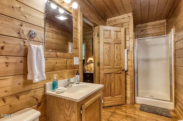 bathroom with vanity, wooden ceiling, a shower with shower door, and wooden walls