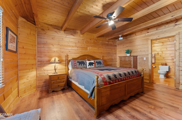 bedroom with wooden ceiling, beamed ceiling, wooden walls, and wood finished floors