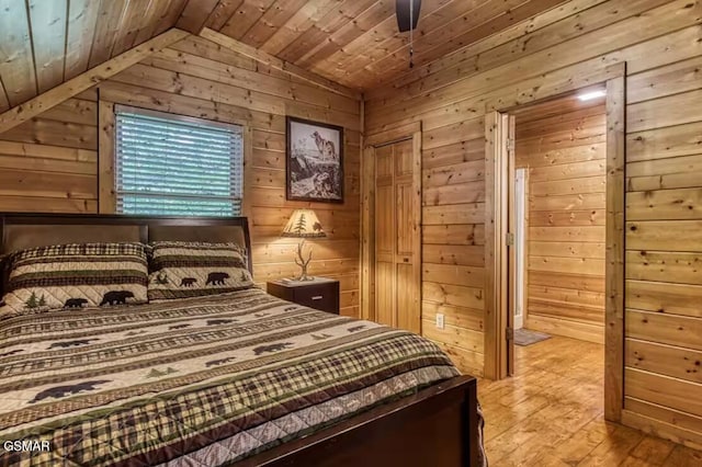 bedroom with wooden ceiling, vaulted ceiling, and wooden walls