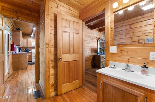 bathroom featuring visible vents, wooden ceiling, wood-type flooring, vanity, and wood walls