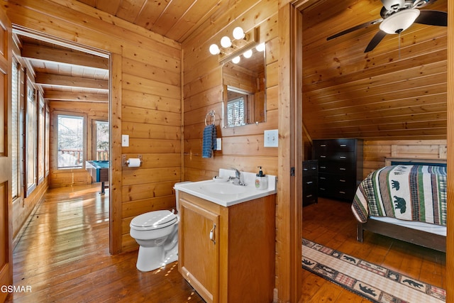 bathroom featuring toilet, wooden walls, vanity, wood ceiling, and wood-type flooring