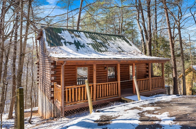 log cabin featuring log siding and metal roof