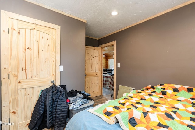 bedroom featuring a textured ceiling and crown molding