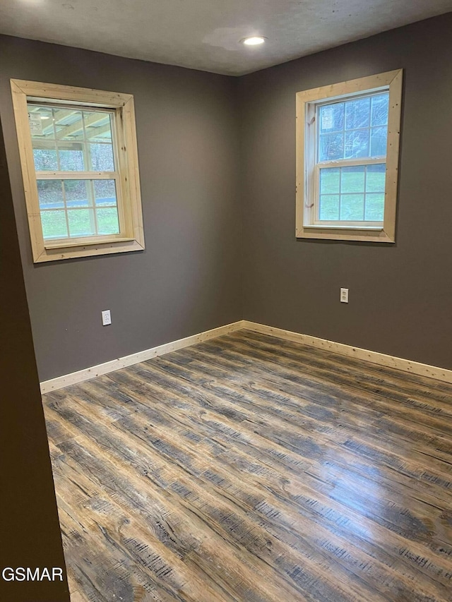 unfurnished room with dark hardwood / wood-style flooring