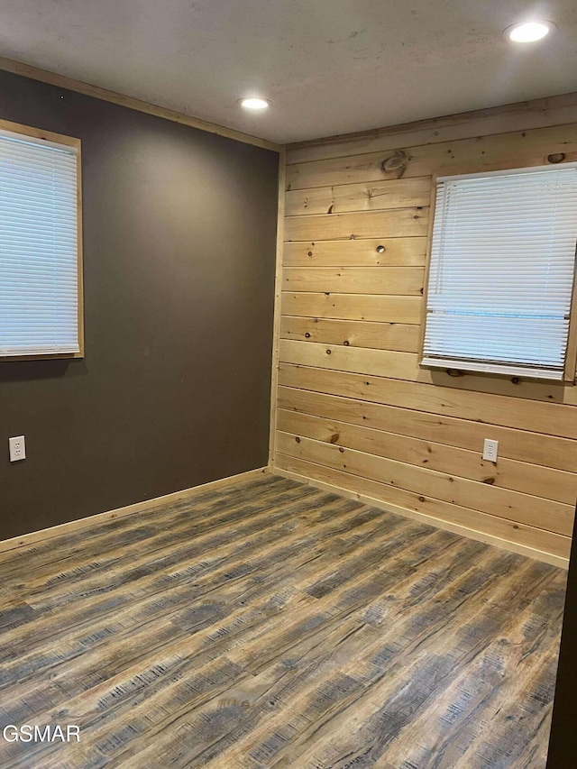 spare room with wood walls and dark wood-type flooring