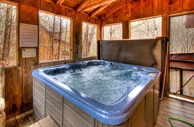 misc room with wooden ceiling, lofted ceiling with beams, a hot tub, hardwood / wood-style floors, and wooden walls