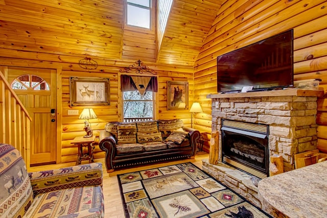 living room featuring plenty of natural light, a stone fireplace, rustic walls, and high vaulted ceiling