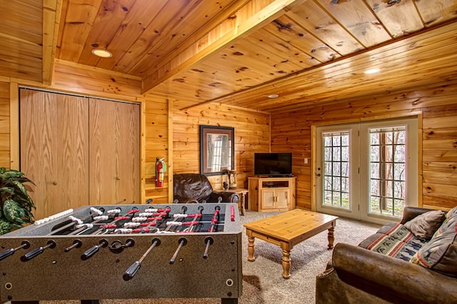 playroom with carpet flooring, wood walls, wooden ceiling, and beamed ceiling