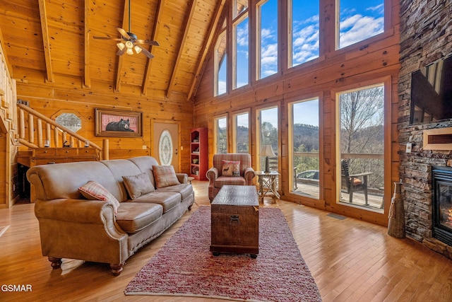 living area with wooden ceiling, light wood-style floors, stairs, and a fireplace