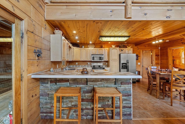 kitchen featuring wood ceiling, stainless steel appliances, a peninsula, and tile counters