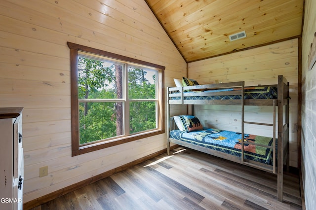 bedroom with wood ceiling, wooden walls, vaulted ceiling, and hardwood / wood-style floors