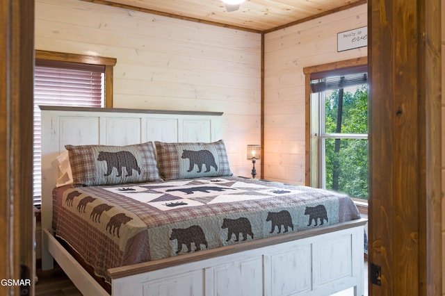 bedroom featuring multiple windows, wooden ceiling, and wooden walls