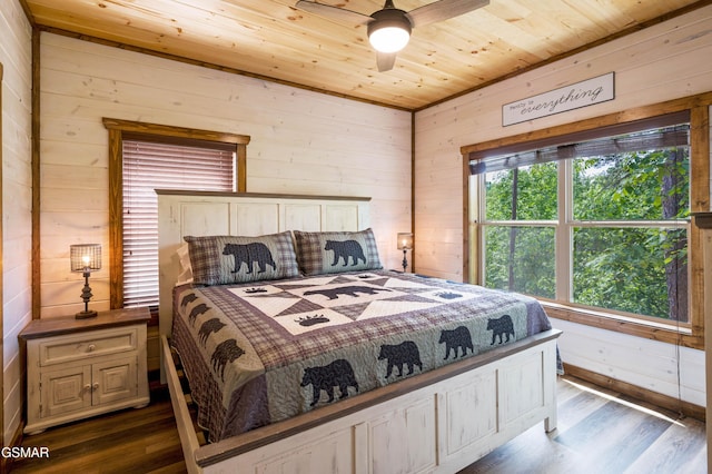 bedroom with ceiling fan, wood walls, dark hardwood / wood-style floors, and wooden ceiling