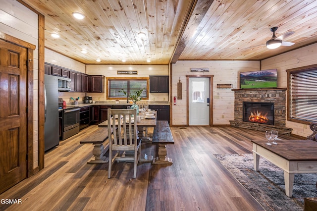 dining area with a fireplace, wooden walls, hardwood / wood-style floors, and wooden ceiling