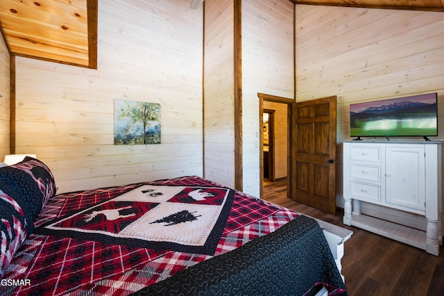 bedroom with a towering ceiling, dark hardwood / wood-style flooring, and wood walls