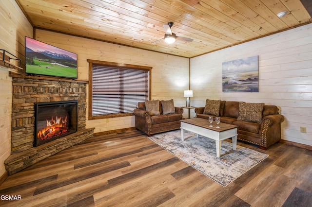 living room featuring wood ceiling, a stone fireplace, hardwood / wood-style floors, and wood walls