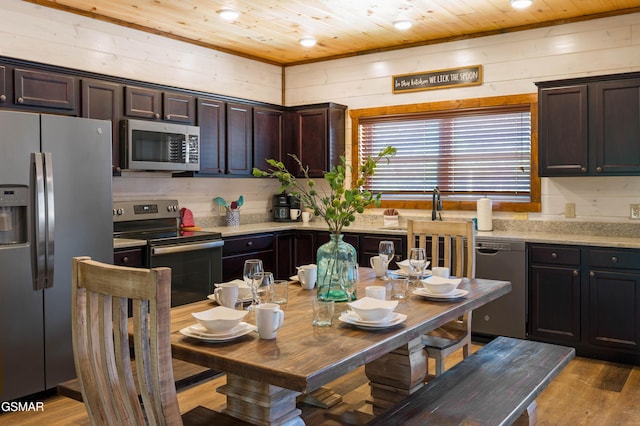 kitchen with appliances with stainless steel finishes, light wood-type flooring, dark brown cabinets, and wooden ceiling