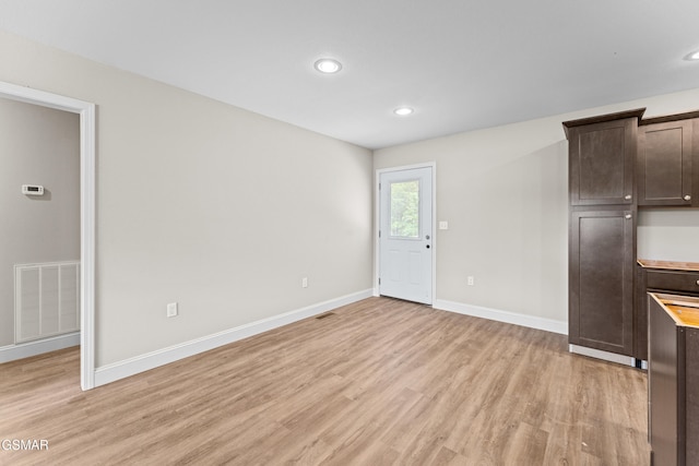 unfurnished living room with light wood finished floors, baseboards, and recessed lighting
